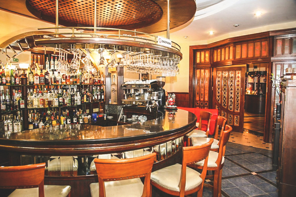 Kardamon bar — circular counter, stemware, warm light