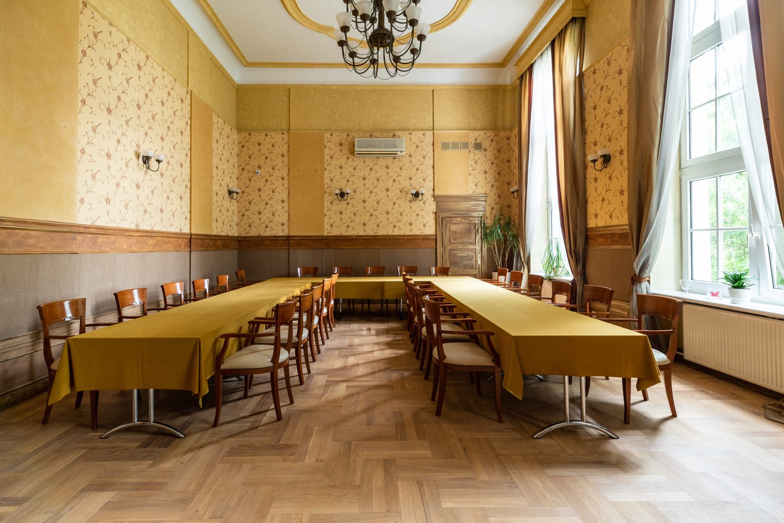 Wedding hall with mustard tablecloths and chandelier